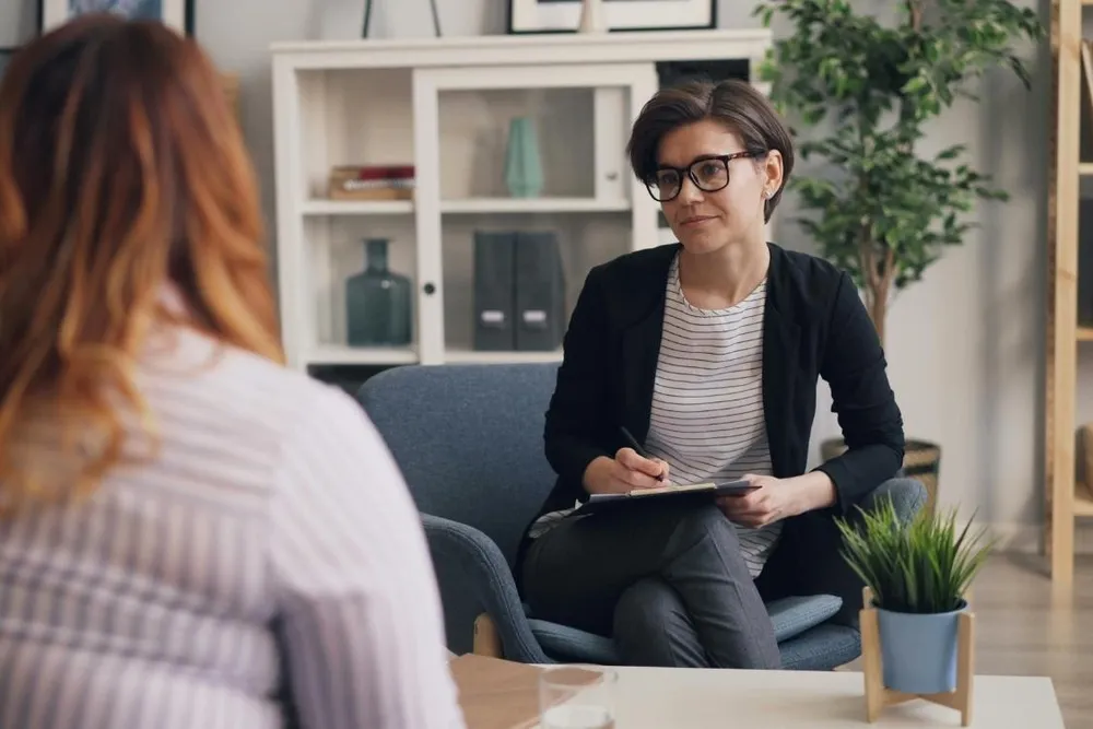 Occupational therapist assessing a client's posture and mobility during a functional capacity assessment