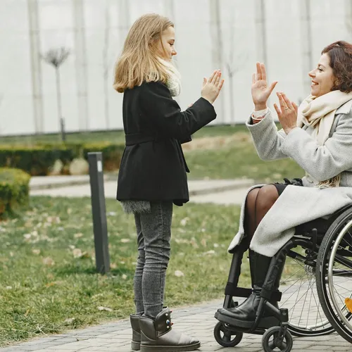 Woman in wheelchair playing with child in a park, representing NDIS community participation
