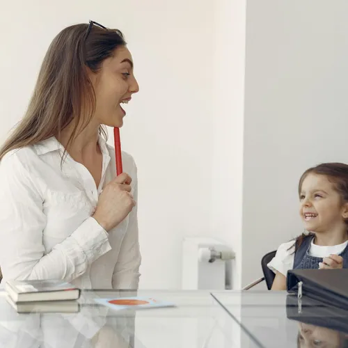 Speech pathologist working with a young child during a therapy session